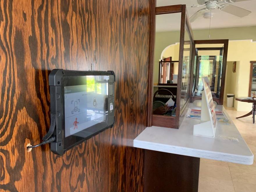 PunchClock clock on a wood-panelled wall beside a hotel reception desk